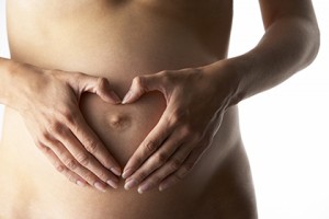 Detail Of Pregnant Woman Forming Heart Shape With Hands